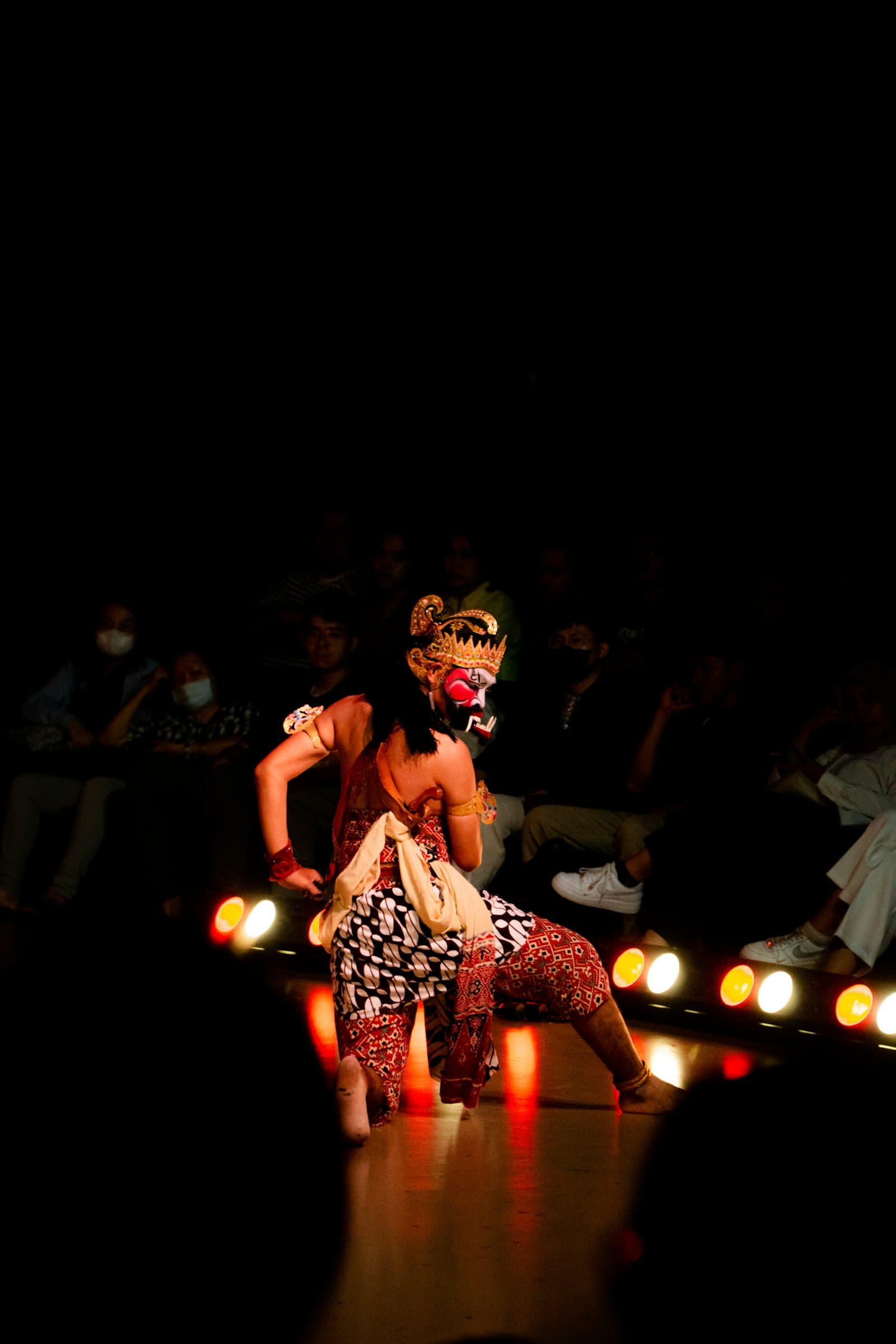 A masked Indonesian traditional dancer mid-performance